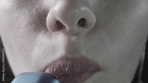 Nose and lips of woman who smokes and breathes out smoke. Close up