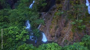 People walks along the waterfall Goa Tetes, people enjoy nature in Java island, Indonesia