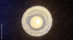 Candle in crystal glass. Candle flame flickering. Flickering flame. Candlelight.