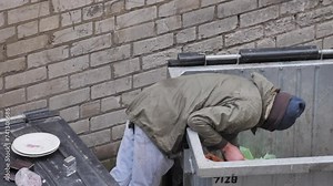 Homeless Man Digging Through Trash Can