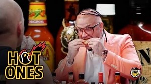 In the latest episode of Hot Ones, Riff Raff—a.k.a. Jody Highroller, a.k.a. Neon Icon, a.k.a. Versace Python—comes through in his finest Peach Panther garments to bring a touch of class to the Internet's most infamous wing challenge. Watch as he and Sean Evans tackle 10 increasingly spicy sauces in the ultimate battle of wits and wills. | First We Feast