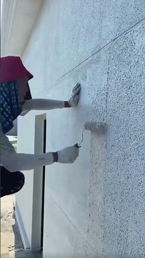 the process of plastering sand powder on the outer walls of a building using a roller #construction
