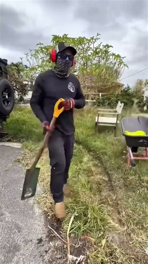 Worker Trimming Lawn Edges Using A String Trimmer