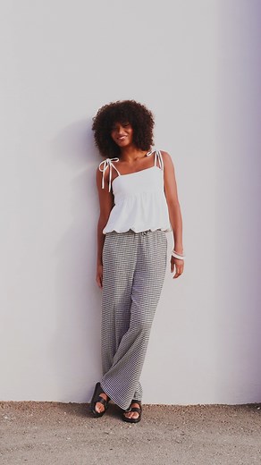 Le pantalon à petits carreaux blanc et noir, un basique simple et léger, parfait pour un look chic sans effort. 🖤🤍 | Vib's Réunion