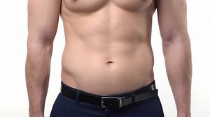 Male athletic muscular torso in office trousers on a white background. The concept of a modern healthy man.