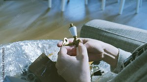 Time-lapse fast motion of woman unboxing in living room small cardboard box containing multiple vintage luxury window handles grip nickel and brass colors comparing the objects after online shopping -