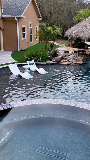 270K views · 7.2K reactions | This is one of our most insane backyards, and it is definitely one of the top pools we have ever built. It's got a Tiki Hut outdoor kitchen with a swim-up bar. It's a massive pool with a huge infinity-edge hot tub, grottos, upon grottos, upon grottos, and a dry cave behind the grottos. It's super lush and tropical. #insanepools #lucaslagoons #pool #poolbuilders #backyard #luxurylife #tikihut | Lucas Lagoons | Facebook