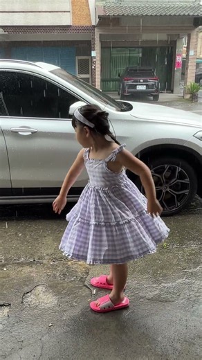 Chloe Standing Under Rainy Porch Cheering Spinning and Reaching Out into Rain.