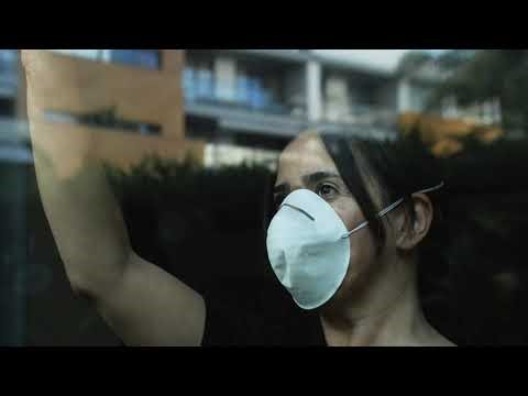 Masked Woman Looking Out Window