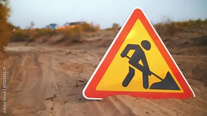 road sign "work in progress" lies on the sand near the quarry