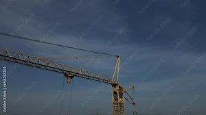 the camera zooms in and out of the high-rise crane. checking the crane operator to see if he fell asleep or died. drone operator is suitable for checking the condition of cables in hard-to-reach place