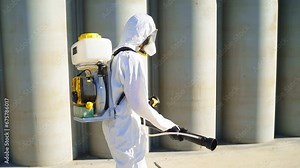Man is a professional in his field, disinfects city streets with a spray gun. Cleaning, disinfection of the city.