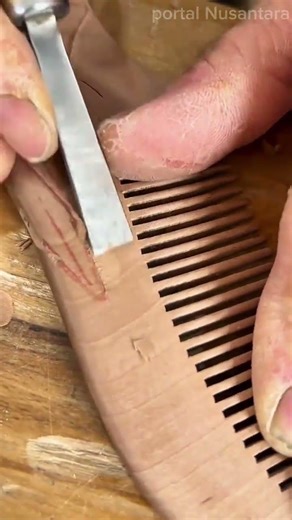 carving decorative patterns on a wooden comb using a sharp chisel tool to create unique textures