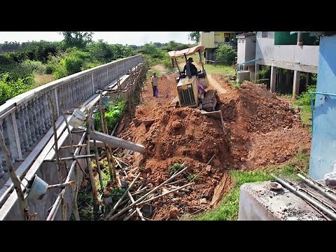Clearing land to bury the foundation posts for the fence surrounding the pagoda under construction