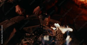 Campfire Coffee: Sparks and flames fly from the campfire as a moka pot sits on the embers and cooks fresh coffee