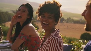 Group of man and women chatting at dinner party outdoors. Millennials enjoying at party in evening.