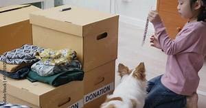 Small gift donate for social issue relief alms unity care at home. Asia little girl kid and mom happy smile help poor people by reuse old used clean clear closet sort stack box zero waste eco saving.