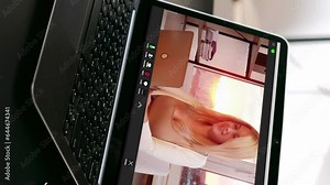 Vertical video. Telework call. Remote meeting. Virtual office. Business woman on laptop screen discussing project with colleague at online conference at modern workplace.