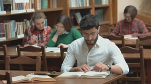Man focused on study for exam in library - Free Stock Video