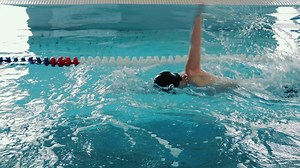 Swimmer splashing in pool lane, Swimmer creating splashes while practicing in a pool lane