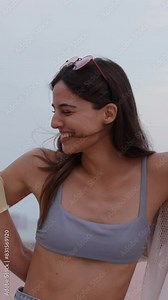 Vertical. Three caucasian friends run holding hands in bikini enjoying vacation at the beach outdoors. Walking in the sand and laughing a lot happy in a sunny day in swimwear celebrate carefree