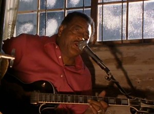 Junior Kimbrough performing at his juke joint in Chulahoma, Mississippi in 1990. | Dust-to-Digital