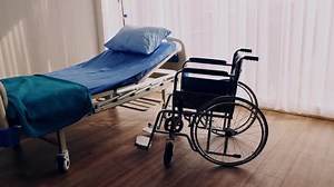 Bedroom for patient in a hospital, Empty bed and wheelchair on hospital ward
