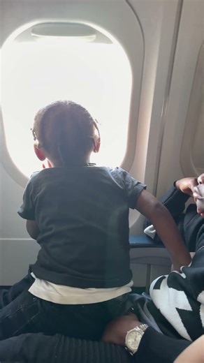 Why my 6yr old AB act like a grown man. ￼ he got my baby on his lap on a plane as if he’s the dad.🤣