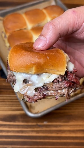 SHREDDED BEEF AND CHEESE SLIDERS! 😋 Ingredients: -King’s Hawaiian Original Hawaiian Sweet Rolls -1 4-5 pound chuck roast -2 tablespoons olive oil -3 tablespoons salt, pepper and garlic blend seasoning -2 onions (sliced) -6 slices Swiss cheese -1/2 cup Mayo -2 tablespoons Worcestershire sauce -1 tablespoon fresh thyme -2 cups beef broth Preparation: 1. Coat chuck roast with olive oil, salt, pepper, and garlic powder 2. Smoke chuck roast at 250 degrees until it reaches an internal temperature of 