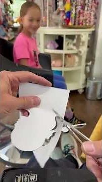 Silhouette artist is hand-cutting a child's silhouette just using scissors and paper!