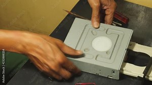 Technician taking off the Bottom Cover Casing of DVD Optical Drive