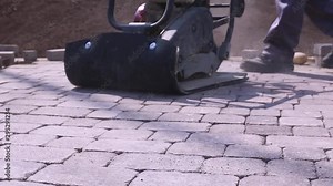 Stone Pavement Road Construction Workers. Using Finishing Plate Compactor