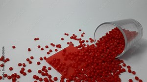 Red masterbatch granules spilled from the sloki.Color pigment carrier polymer in the plastics industry