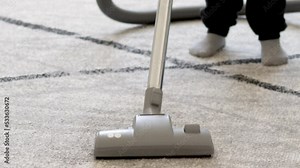 kid cleaning room with vacuum cleaner.baby little preschooler boy clean gray color carpet laminate floor from dust trash garbage,housekeeping little mothers helper.close up legs socks 4k real time