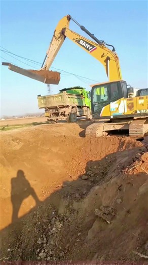 Excavator Loads Dirt into Truck, Visible Construction Efficiency