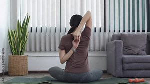Woman doing yoga in living room, Exercising for health.