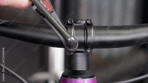 Meticulous handlebar installation on mountain bike by bicycle mechanic - closeup of torque wrench tightening bolts with even pressure. Speed ramp