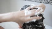 Woman washing her hair with shampoo. Hair care, beauty concept.
