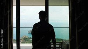 couple in hotel room by the sea, man opens curtains, hugging at the window Stock Video