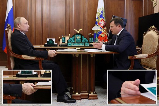 Putin was seen once again furiously gripping a table for support during a meeting as his veins bulged