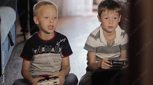 two boys playing computer games sitting at home
