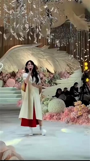 🇨🇳 她带着一种静谧的力量走向舞台。在众人的注视下，她从容地握住麦克风，目光中充满了历经岁月洗礼后的厚重与慈悲。她用那充满爱意且沉稳的声音，唱出了生命中最真挚的领悟，这份谦卑与纯粹让在场众人的眼眶不禁湿润： 🇬🇧 She walks toward the stage with a power of stillness. Under the gaze of the crowd, she calmly holds the microphone, her eyes filled with depth and compassion gained through the years. With a loving and steady voice, she sings her most sincere realization of life, a humility and purity that brings tears to the eyes of almost everyone present: 🇨🇳「听，这旋律中流淌的是光阴的真言。我今天站在这里，心中没有半点尘埃，只有对这段生命