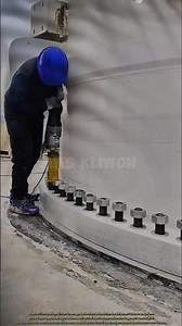 Cet homme installe des boulons à l'aide d'outils hydrauliques.