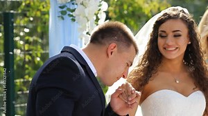 Bride and groom on wedding ceremony. Man kiss the hand of his bride.