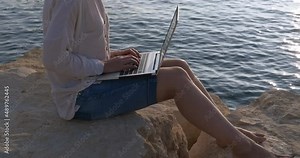 Use laptop on the beach. A female use laptop during her summer vacation on the shore.