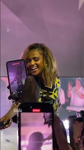 Tyla gives a fan the mic during her “Water” performance at the Prelude To The Olympics 2024