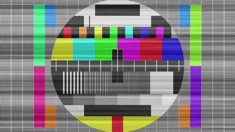 A classic TV test pattern featuring color bars, grayscale, and calibration lines for broadcasting