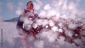 SLOW MOTION, CLOSE UP Smiling woman sleds down the hill on a saucer snow sled. Winter sun is shining and flying snow is glistening as she brakes while sledging. Sunny day for outdoor winter activities
