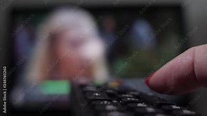 channel switching by remote control, close-up, woman switches channels on TV