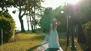 Traveler woman walking on path to the tropical beach at a luxury resort. Enjoying a blissful vacation in paradise, surrounded by natures beauty.